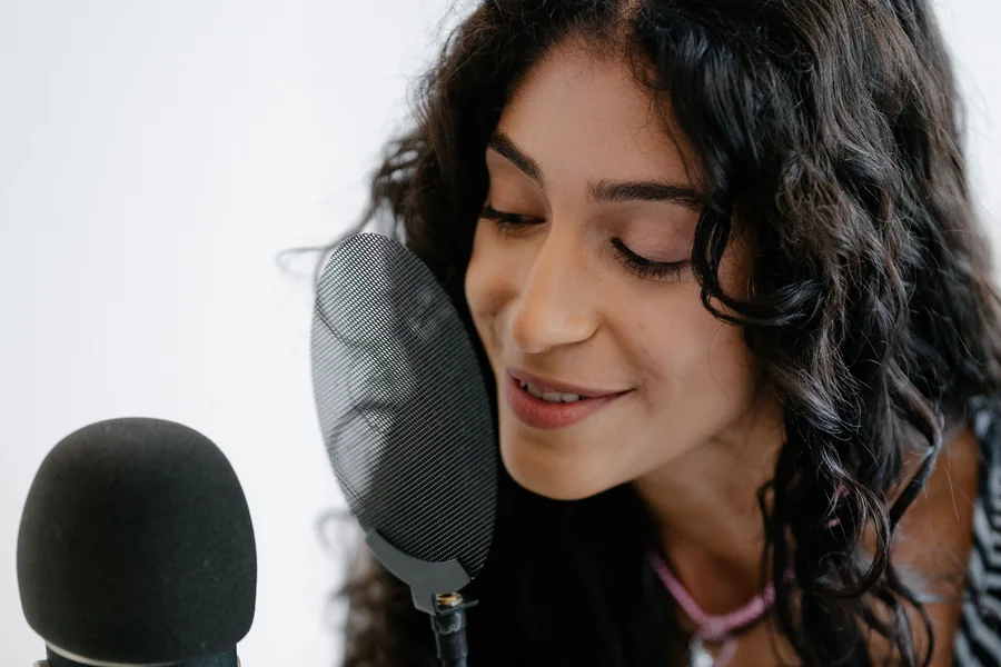 マイクに向かって音声を収録する女性