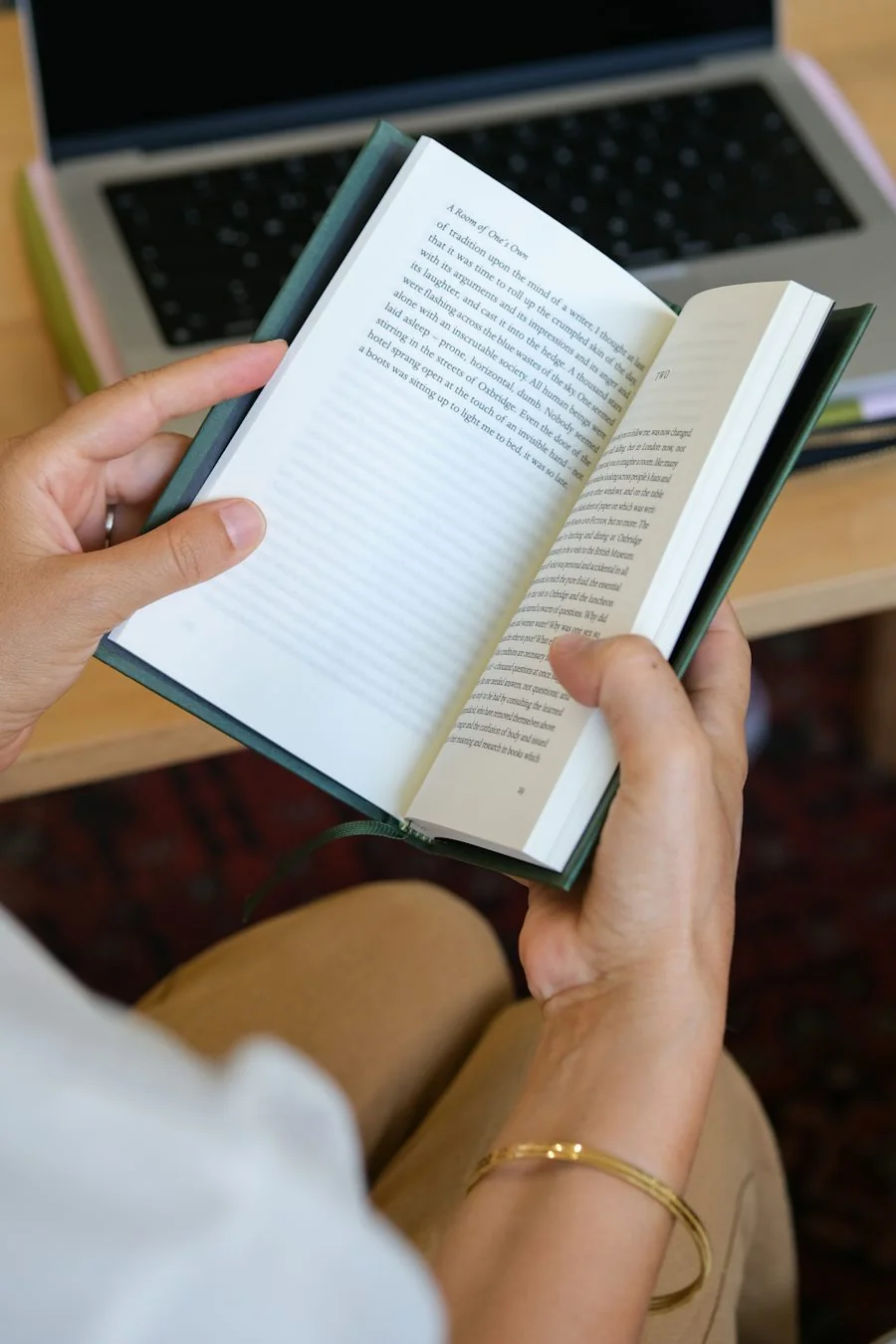 パソコンの前で英語の本を開いて読む手元